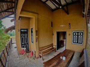 eine Veranda eines Hauses mit einer Bank und Stühlen in der Unterkunft The Loft by the Lake in Kurunegala