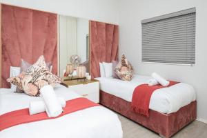 a bedroom with two beds and a window at Trendy Apartment in Century City in Cape Town