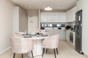 a kitchen with a table with chairs and a refrigerator at Trendy Apartment in Century City in Cape Town