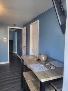 a dining room with a wooden table and a blue wall at Amble Harbour retreats in Amble