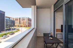 a balcony with a table and a bottle of wine at Trendy Apartment in Century City in Cape Town