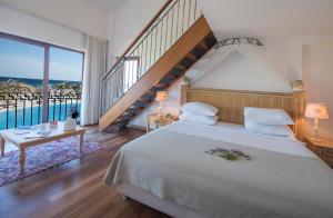 a bedroom with a large bed and a staircase at Cocos The Club Solto in Alaçatı