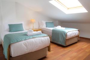 a bedroom with two beds and a skylight at Cocos The Club Solto in Alacati