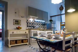 ナポリにあるLa Casa Napoletana - LS Accommodationsのキッチン(テーブル、椅子付)