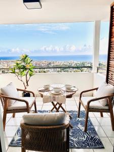 d'un balcon avec une table et des chaises offrant une vue sur la ville. dans l'établissement Perle insulaire, à Saint-Denis