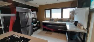 a kitchen with a stainless steel refrigerator and a sink at Villa O'Sables in Pointe aux Sable