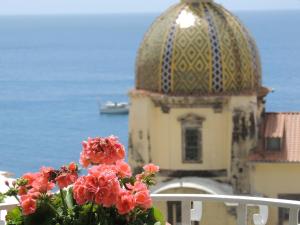 un edificio con cupola e fiori sul balcone di La Tavolozza Residence a Positano