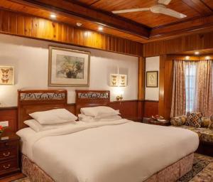 a bedroom with a large bed and a couch at Mayfair Darjeeling in Darjeeling