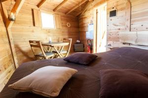 um quarto com uma cama num chalé de madeira em Les Cabanes de Fontfroide em Saint-Antoine