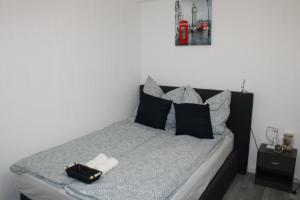 um quarto com uma cama com almofadas pretas e cinzentas em Ruhiges & schickes 4 Zi-Apartment em Heilbronn