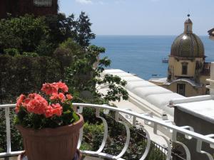 eine Topfpflanze auf einem Balkon mit Meerblick in der Unterkunft La Tavolozza Residence in Positano