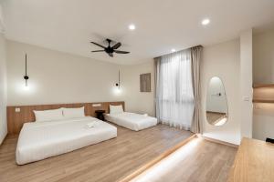 sypialnia z 2 łóżkami i wentylatorem sufitowym w obiekcie Codrington House - Boutique Apartments w mieście George Town