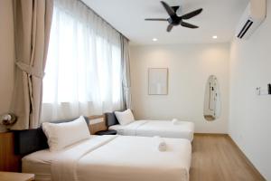 a hotel room with two beds and a ceiling fan at Codrington House - Boutique Apartments in George Town
