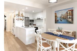 a kitchen and living room with a table and a kitchen and a dining room at Caloundra Poolside Paradise in Caloundra