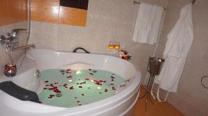 a bathroom with a large tub with flowers on the floor at Хотел Стиляна/Hotel Stilyana in Devin