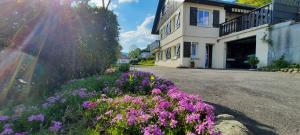 a house with purple flowers on the side of a street at plain-pied proche base de loisirs et voie verte in Saulxures-sur-Moselotte