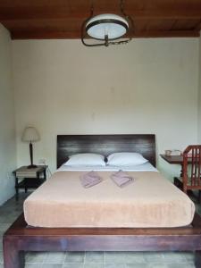 una camera con un grande letto con testiera in legno di Guru Ratna a Munduk