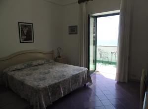 a bedroom with a bed and a large sliding glass door at La Tavolozza Residence in Positano +27 photos