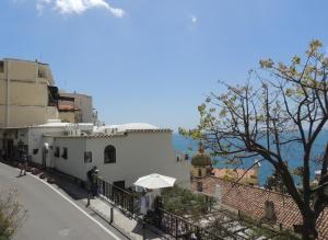 a street with a white building and an umbrella at La Tavolozza Residence in Positano