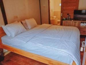 a bedroom with a large bed with blue sheets and pillows at Mayeka Transit Hostel Bandara Internasional Lombok in Praya