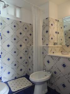 a bathroom with a white toilet and a sink at La Tavolozza Residence in Positano
