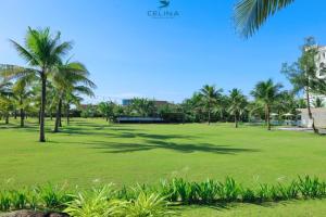 um parque com palmeiras e um edifício em Celina Peninsula Resort Quảng Bình em Dương Cảnh