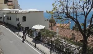 a person walking down a street with an umbrella at La Tavolozza Residence in Positano