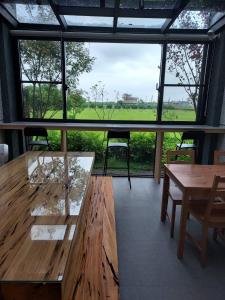a room with a table and chairs and a large window at Lakeforest B&B in Yuanshan