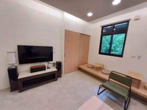 a living room with a large flat screen tv at Lakeforest B&B in Yuanshan