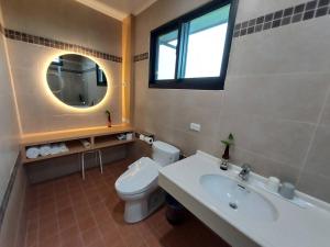 a bathroom with a toilet and a sink and a mirror at Lakeforest B&B in Yuanshan