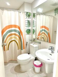 a bathroom with a toilet and a sink and a shower curtain at S&N Azure Staycation in Manila