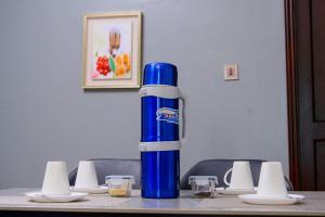 une bouteille d'eau bleue assise au-dessus d'une table dans l'établissement 3 Bedroom Family Apartment, à Namulanda