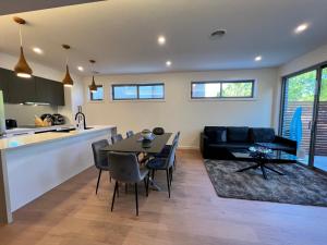 een keuken en een woonkamer met een tafel en een bank bij Stunning Dickson Luxe 3BR 2Bath Double Garage WiFi Brand New Home in Canberra