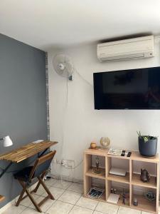 sala de estar con TV, mesa y silla en Studio 14 proche GRR2 97400, en Saint-Denis