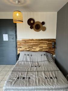 a bed with a wooden headboard and two donuts on the wall at Studio 14 proche GRR2 97400 in Saint-Denis