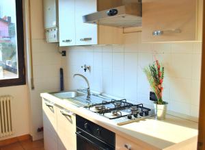 a kitchen with a sink and a stove at Belvedere - Apartment with Balcony Lake View in Sala Comacina