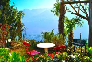 a table and chairs with a view of the ocean at Belvedere - Apartment with Balcony Lake View in Sala Comacina