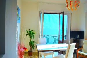 a room with a table and chairs and a window at Belvedere - Apartment with Balcony Lake View in Sala Comacina