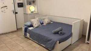 um quarto com uma cama com lençóis e almofadas azuis em Virgy’s House em Sestu