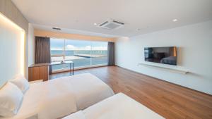 慶州市にあるSharp & Flat Hotelの白いベッドが備わるベッドルーム1室から海の景色を望めます。