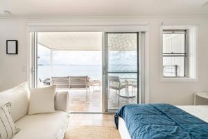 um quarto com uma cama e vista para o oceano em Fogo @ Ethel & Ode’s em Bundeena
