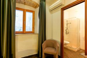 La salle de bains est pourvue d'une chaise, d'une fenêtre et d'une douche. dans l'établissement Il Palazz8, à Iglesias