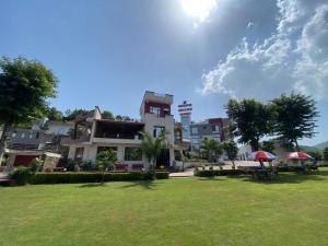 a group of buildings with tables and umbrellas in a park at Meera Valley Resort in Udaipur
