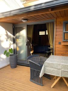 un porche cubierto con mesa y silla en Le Chalet du Domaine en La Saline les Bains