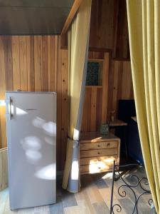 Cette chambre est dotée d'un mur en bois et d'un réfrigérateur. dans l'établissement Le Chalet du Domaine, à La Saline les Bains