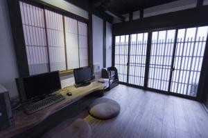 una oficina con un escritorio con un ordenador y dos monitores en Shirafuji-an, en Kioto