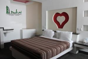 a bedroom with a bed with a red heart on the wall at Motel Dubái Ensenada in Ensenada