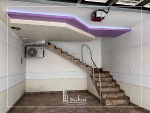 a staircase in a building with a purple ceiling at Motel Dubái Ensenada in Ensenada