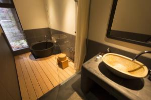 a bathroom with a sink and a bath tub at Shirafuji-an Modern Private Machiya in Central Kyoto in Kyoto