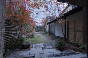 a walkway in a yard next to a building at Shirafuji-an in Kyoto